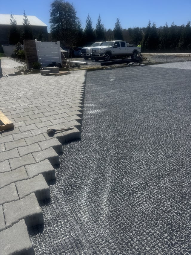 Parking lot expansion in progress showing professional paver installation and site preparation
